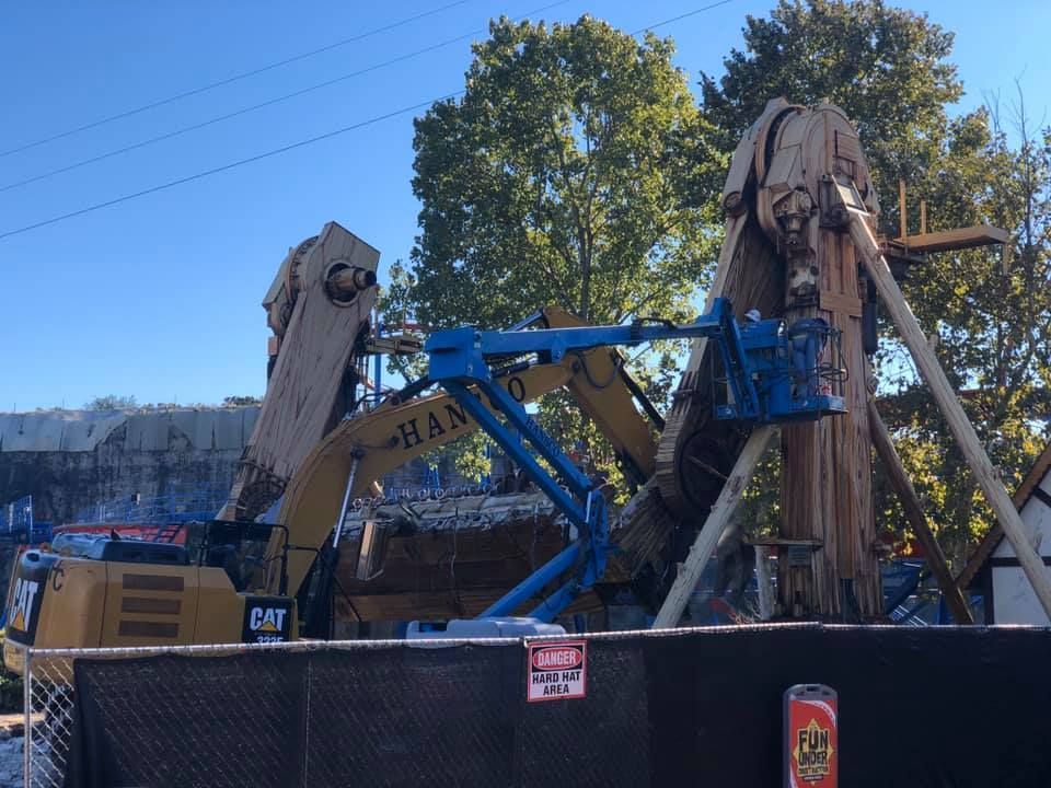 Hansco excavator and boom lift dismantling a wooden amusement park ride