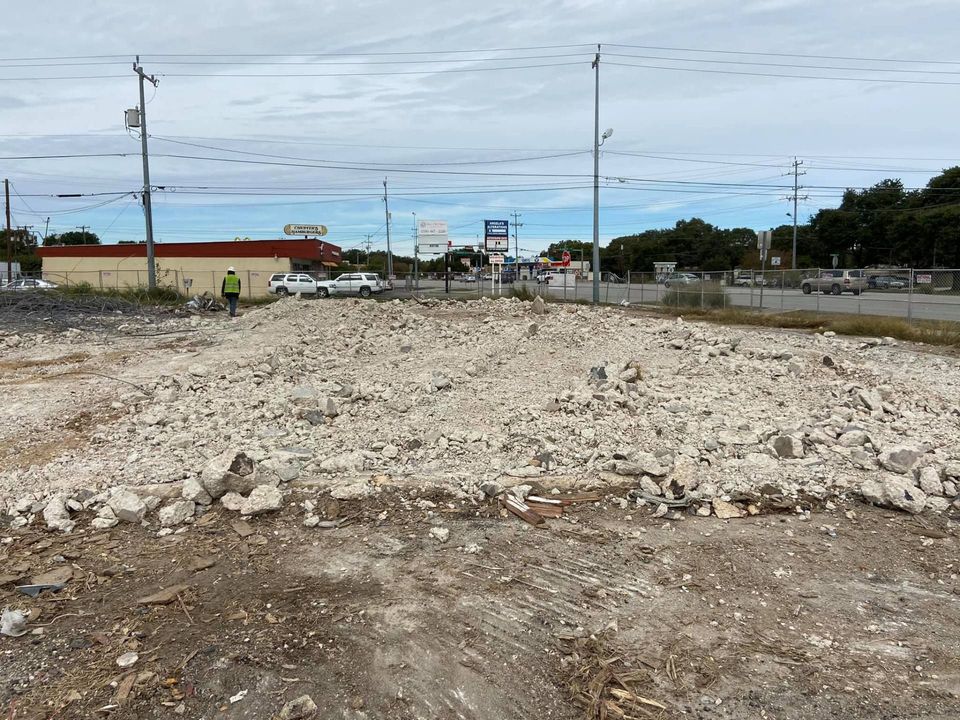 Cleared demolition lot with piles of broken concrete rubble waiting to be hauled off