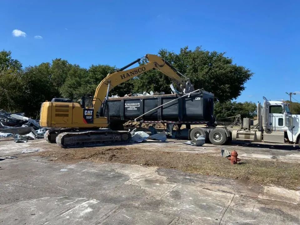 Excavator loading demolition debris for haul-off