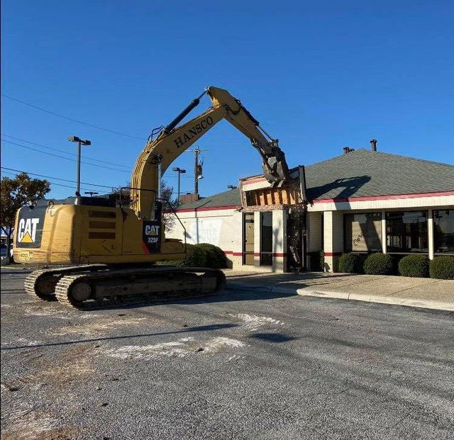 Hansco CAT excavator tearing into a single-story restaurant building from the parking lot