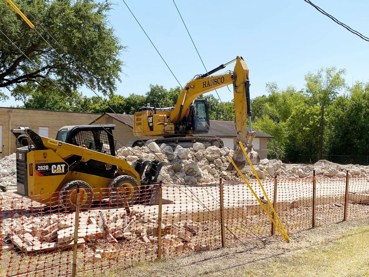 Hansco excavator and skid steer clearing a demolition site