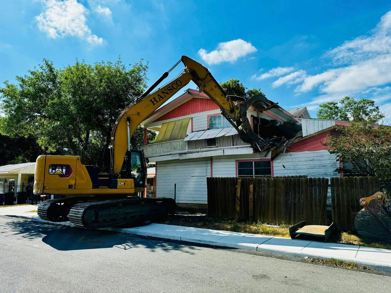Residential demolition in progress with heavy equipment on site